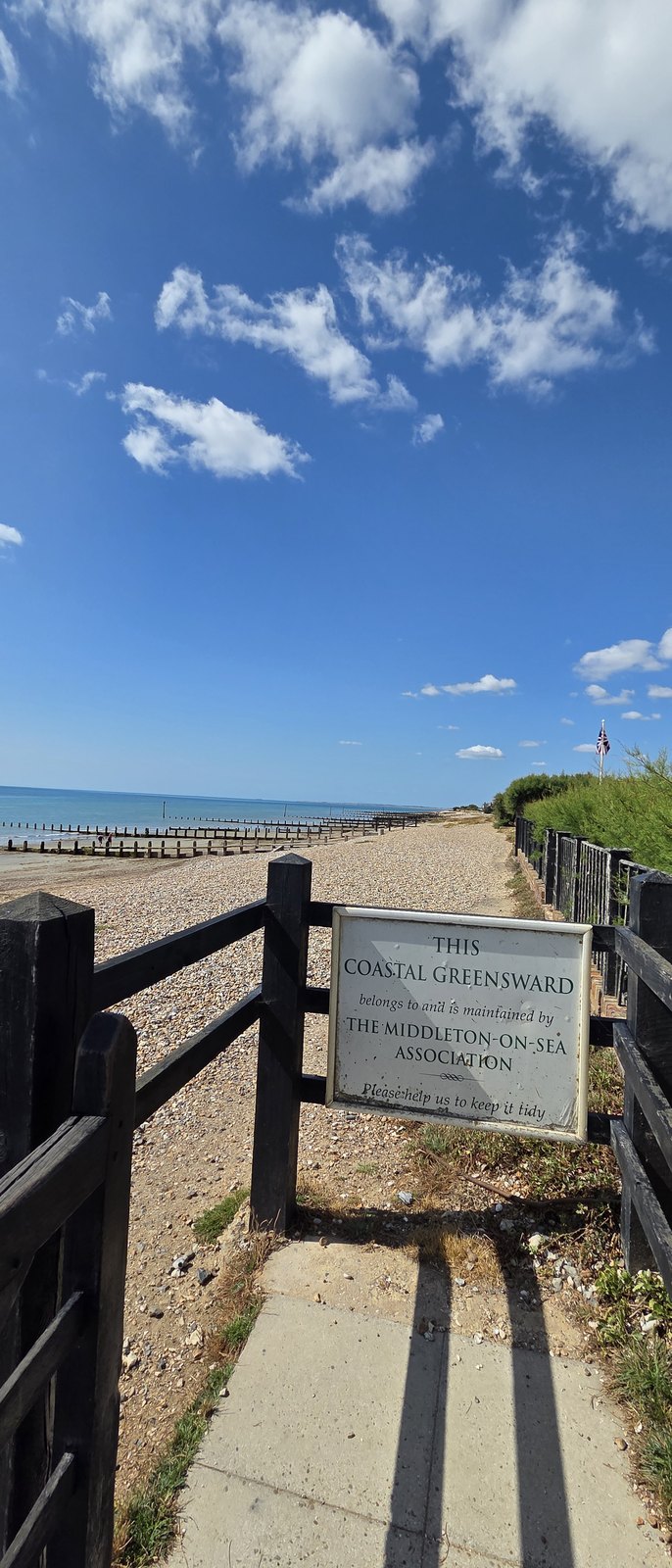 A white painted sign on a low timber post reading: this coastal greensward belongs to and is maintained by the Middleton-on-Sea Association, please help us to keep it tidy