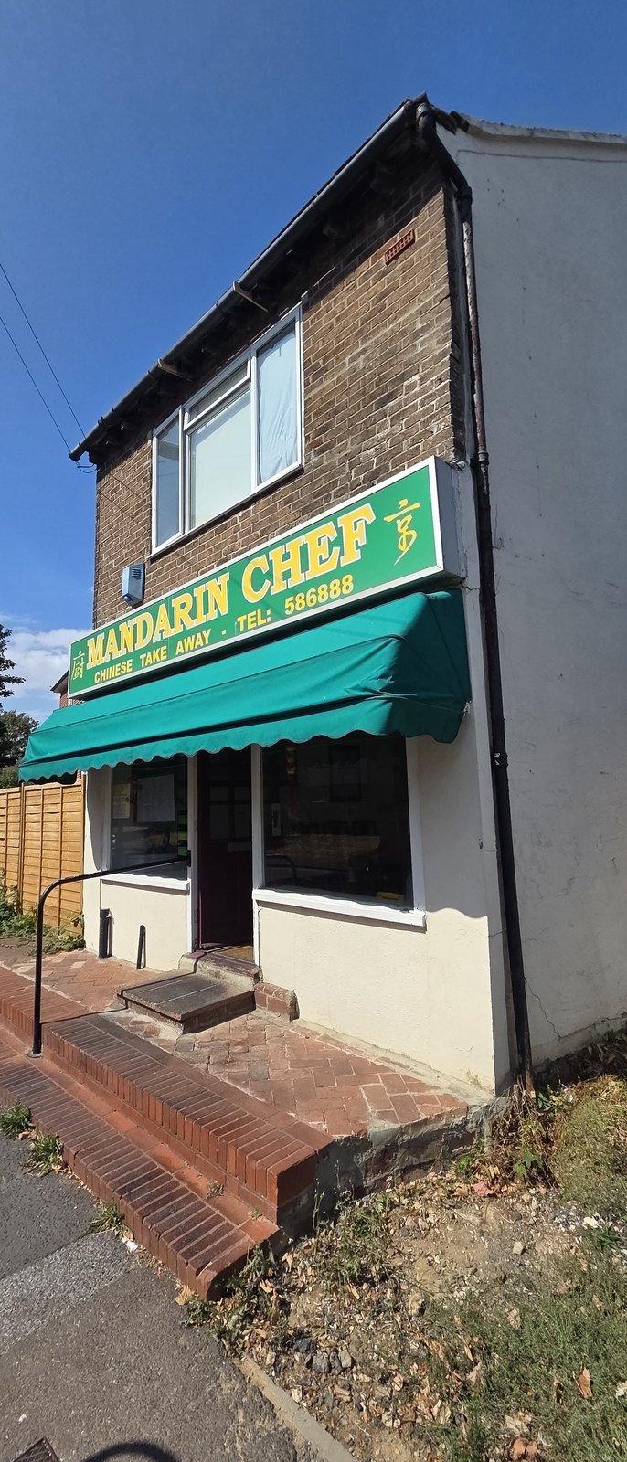 Mandarin Chef, a small brick shop with a green awning and a green and yellow sign reading Mandarin Chef Chinese Take Away